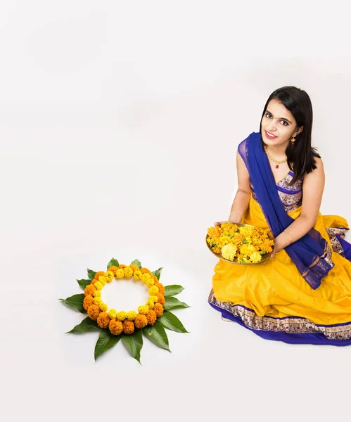 Indiase vrouw of meisje maken van bloemen of bloem rangoli voor diwali of onam, geïsoleerd op witte achtergrond — Stockfoto