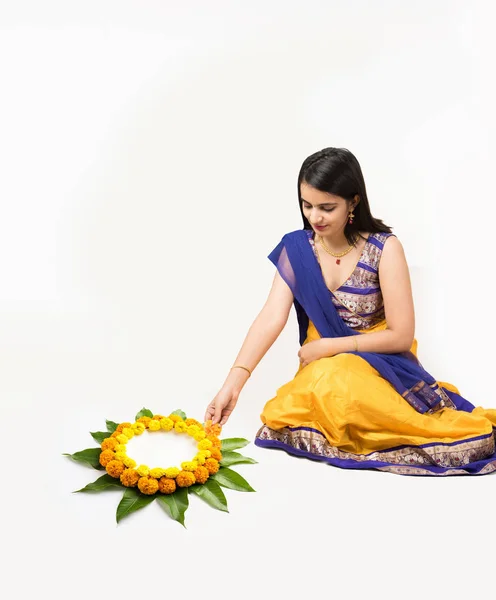 Indiase vrouw of meisje maken van bloemen of bloem rangoli voor diwali of onam, geïsoleerd op witte achtergrond — Stockfoto