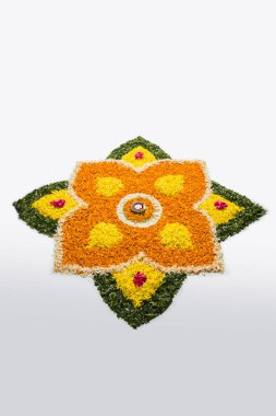çiçek rangoli Diwali için veya pongal veya diwali diya orta, seçici odak ile beyaz arka plan üzerinde kadife çiçeği veya zendu çiçekler ve kırmızı gül yaprakları kullanılarak yapılan onam