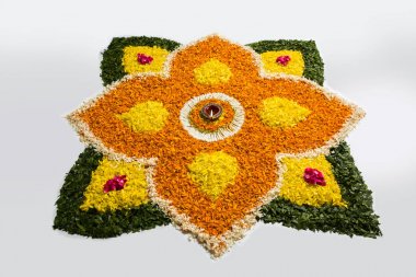 çiçek rangoli Diwali için veya pongal veya diwali diya orta, seçici odak ile beyaz arka plan üzerinde kadife çiçeği veya zendu çiçekler ve kırmızı gül yaprakları kullanılarak yapılan onam