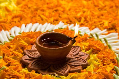 çiçek rangoli Diwali için veya pongal veya diwali diya orta, seçici odak ile beyaz arka plan üzerinde kadife çiçeği veya zendu çiçekler ve kırmızı gül yaprakları kullanılarak yapılan onam