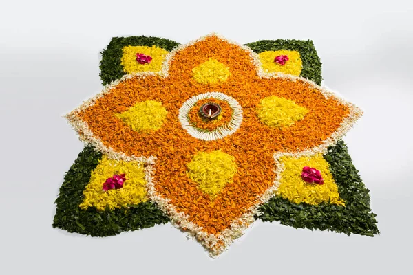 Gama de flores para Diwali o pongal o onam hechas con flores de caléndula o zendu y pétalos de rosa roja sobre fondo blanco con diwali diya en el centro, enfoque selectivo —  Fotos de Stock