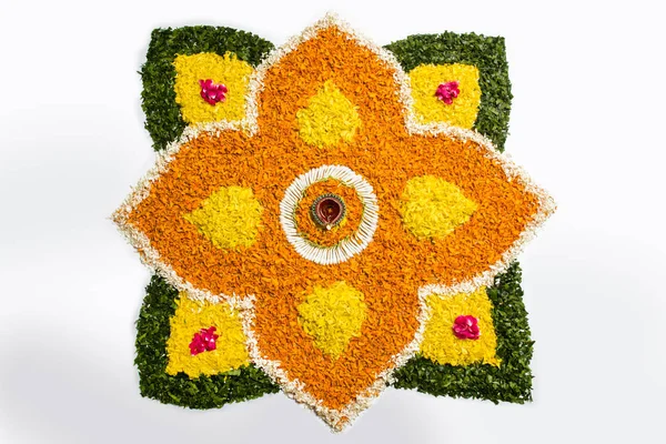 çiçek rangoli Diwali için veya pongal veya diwali diya orta, seçici odak ile beyaz arka plan üzerinde kadife çiçeği veya zendu çiçekler ve kırmızı gül yaprakları kullanılarak yapılan onam