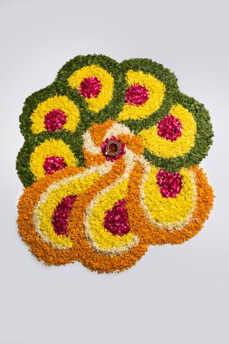 çiçek rangoli Diwali için veya pongal veya diwali diya orta, seçici odak ile beyaz arka plan üzerinde kadife çiçeği veya zendu çiçekler ve kırmızı gül yaprakları kullanılarak yapılan onam