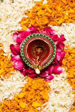 çiçek rangoli Diwali için veya pongal veya diwali diya orta, seçici odak ile beyaz arka plan üzerinde kadife çiçeği veya zendu çiçekler ve kırmızı gül yaprakları kullanılarak yapılan onam
