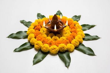 çiçek rangoli Diwali için veya pongal veya diwali diya orta, seçici odak ile beyaz arka plan üzerinde kadife çiçeği veya zendu çiçekler ve kırmızı gül yaprakları kullanılarak yapılan onam