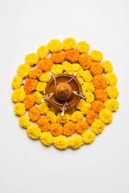çiçek rangoli Diwali için veya pongal veya diwali diya orta, seçici odak ile beyaz arka plan üzerinde kadife çiçeği veya zendu çiçekler ve kırmızı gül yaprakları kullanılarak yapılan onam