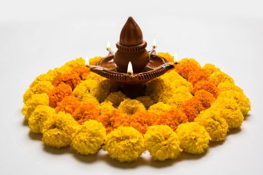 çiçek rangoli Diwali için veya pongal veya diwali diya orta, seçici odak ile beyaz arka plan üzerinde kadife çiçeği veya zendu çiçekler ve kırmızı gül yaprakları kullanılarak yapılan onam