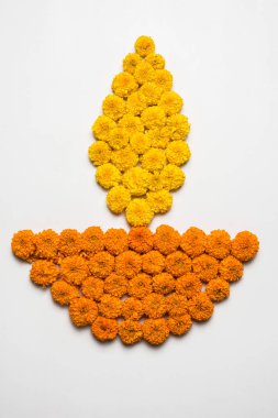 çiçek rangoli Diwali için veya pongal veya diwali diya orta, seçici odak ile beyaz arka plan üzerinde kadife çiçeği veya zendu çiçekler ve kırmızı gül yaprakları kullanılarak yapılan onam