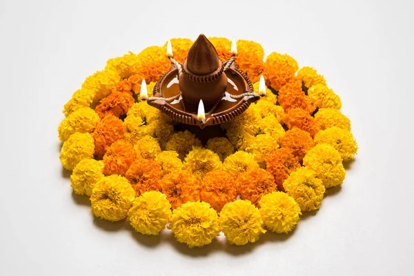 Gama de flores para Diwali o pongal o onam hechas con flores de caléndula o zendu y pétalos de rosa roja sobre fondo blanco con diwali diya en el centro, enfoque selectivo —  Fotos de Stock