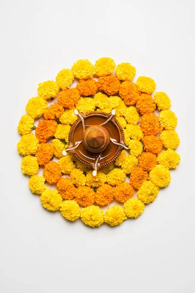 Gama de flores para Diwali o pongal o onam hechas con flores de caléndula o zendu y pétalos de rosa roja sobre fondo blanco con diwali diya en el centro, enfoque selectivo —  Fotos de Stock