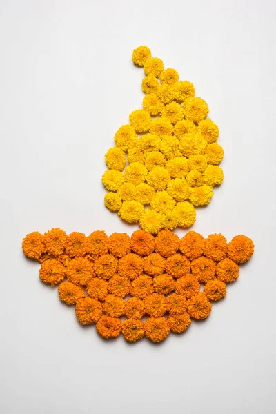 Gama de flores para Diwali o pongal o onam hechas con flores de caléndula o zendu y pétalos de rosa roja sobre fondo blanco con diwali diya en el centro, enfoque selectivo —  Fotos de Stock