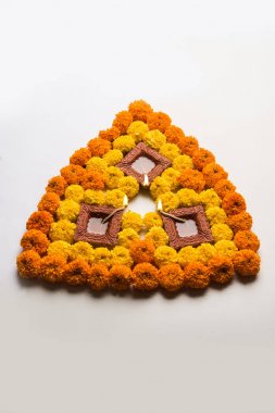 çiçek rangoli Diwali için veya pongal veya diwali diya orta, seçici odak ile beyaz arka plan üzerinde kadife çiçeği veya zendu çiçekler ve kırmızı gül yaprakları kullanılarak yapılan onam