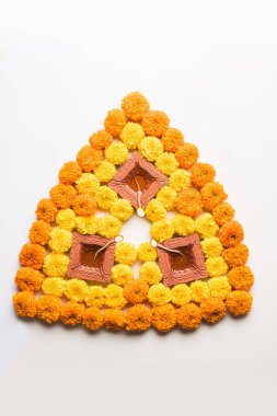 çiçek rangoli Diwali için veya pongal veya diwali diya orta, seçici odak ile beyaz arka plan üzerinde kadife çiçeği veya zendu çiçekler ve kırmızı gül yaprakları kullanılarak yapılan onam
