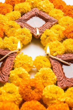 çiçek rangoli Diwali için veya pongal veya diwali diya orta, seçici odak ile beyaz arka plan üzerinde kadife çiçeği veya zendu çiçekler ve kırmızı gül yaprakları kullanılarak yapılan onam