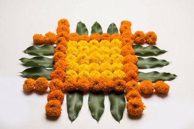 çiçek rangoli Diwali için veya pongal veya diwali diya orta, seçici odak ile beyaz arka plan üzerinde kadife çiçeği veya zendu çiçekler ve kırmızı gül yaprakları kullanılarak yapılan onam