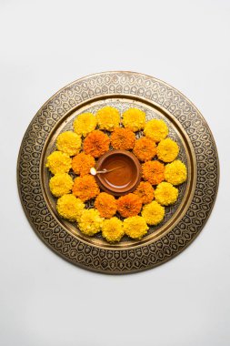 çiçek rangoli Diwali için veya pongal veya diwali diya orta, seçici odak ile beyaz arka plan üzerinde kadife çiçeği veya zendu çiçekler ve kırmızı gül yaprakları kullanılarak yapılan onam