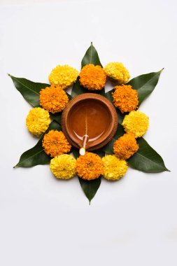 çiçek rangoli Diwali için veya pongal veya diwali diya orta, seçici odak ile beyaz arka plan üzerinde kadife çiçeği veya zendu çiçekler ve kırmızı gül yaprakları kullanılarak yapılan onam