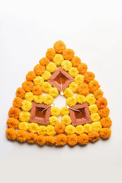 çiçek rangoli Diwali için veya pongal veya diwali diya orta, seçici odak ile beyaz arka plan üzerinde kadife çiçeği veya zendu çiçekler ve kırmızı gül yaprakları kullanılarak yapılan onam