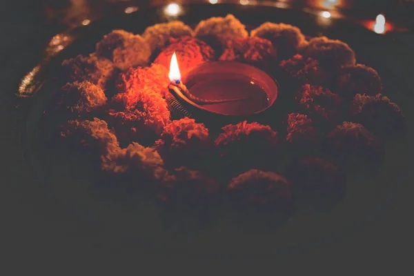 Blomma rangoli för Diwali eller pongal eller onam gjorts med ringblomma eller zendu blommor och röda rosenblad över vit bakgrund med diwali diya i mitten, selektiv fokus — Stockfoto