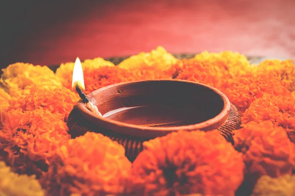 çiçek rangoli Diwali için veya pongal veya diwali diya orta, seçici odak ile beyaz arka plan üzerinde kadife çiçeği veya zendu çiçekler ve kırmızı gül yaprakları kullanılarak yapılan onam