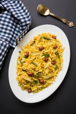Indian traditional and popular snack poha chivda or chivada made from frying items like thin flattened rice, red chili, curry leaves, groundnuts, cashew nuts and almonds. selective focus clipart