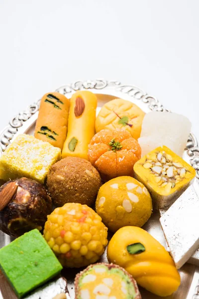 Foto de stock de dulces indios servidos en plata o plato de madera. variedad de Peda, burfi, laddu en placa decorativa, enfoque selectivo — Foto de Stock