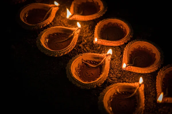 Happy diwali - viele Terrakottadyas oder Öllampen, die über Lehmoberfläche oder Boden in einer Linie oder in gebogener oder Zickzackform angeordnet sind, selektiver Fokus — Stockfoto