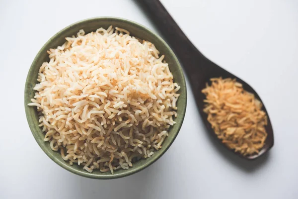 Foto de caldo de indio integral basmati arroz cocido y arroz crudo, servido en un tazón. enfoque selectivo — Foto de Stock