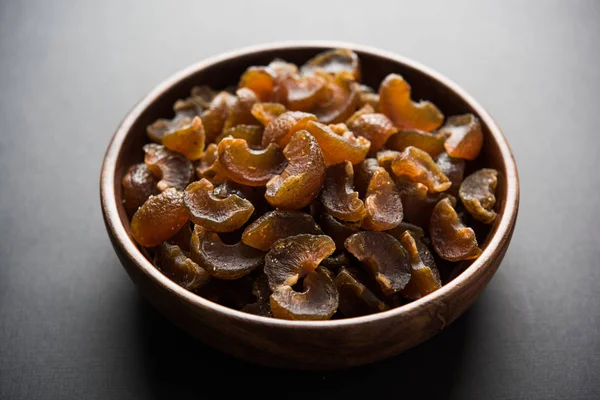 Аюрведические конфеты Амла, которые сушеные и соленые или чатпата по вкусу и пищеварению. Подается в деревянной чаше, избирательный фокус — стоковое фото