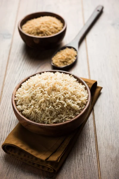 Stock photo of Indian brown wholegrain basmati cooked rice and raw rice, served in a bowl. selective focus