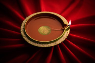 Büyük ışıklı diwali diya veya kil lamba Işınları etkisi oluşturma bez, moody aydınlatma, seçici odak saten kumaş üzerine yerleştirilen