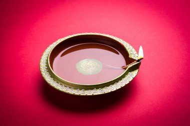 Büyük ışıklı tasarımcı diwali diya veya kil lamba yerleştirilmiş kırmızı arka plan, moody aydınlatma, seçici odak üzerinde