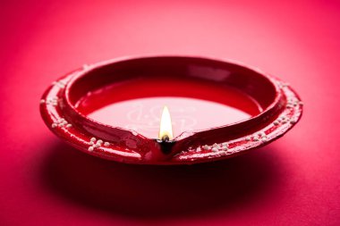 Büyük ışıklı tasarımcı diwali diya veya kil lamba yerleştirilmiş kırmızı arka plan, moody aydınlatma, seçici odak üzerinde