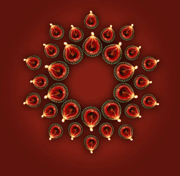 Stock photo of diwali greeting card showing top view of illuminated diya or oil lamp or panti forming a design or rangoli copy space and with Happy Diwali text — Stock Photo, Image