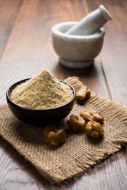 Şeytantersi kek ve toz veya Hing veya Hint yemek tarifleri ile büyük tahta kaşık ve harç, seçici odak önemli bir madde olan Heeng