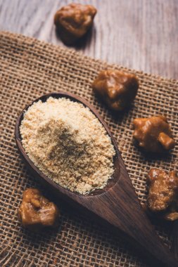 Şeytantersi kek ve toz veya Hing veya Hint yemek tarifleri ile büyük tahta kaşık ve harç, seçici odak önemli bir madde olan Heeng