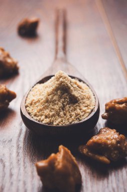 Şeytantersi kek ve toz veya Hing veya Hint yemek tarifleri ile büyük tahta kaşık ve harç, seçici odak önemli bir madde olan Heeng