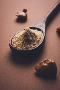 Şeytantersi kek ve toz veya Hing veya Hint yemek tarifleri ile büyük tahta kaşık ve harç, seçici odak önemli bir madde olan Heeng