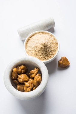 Şeytantersi kek ve toz veya Hing veya Hint yemek tarifleri ile büyük tahta kaşık ve harç, seçici odak önemli bir madde olan Heeng