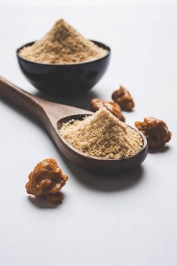 Şeytantersi kek ve toz veya Hing veya Hint yemek tarifleri ile büyük tahta kaşık ve harç, seçici odak önemli bir madde olan Heeng