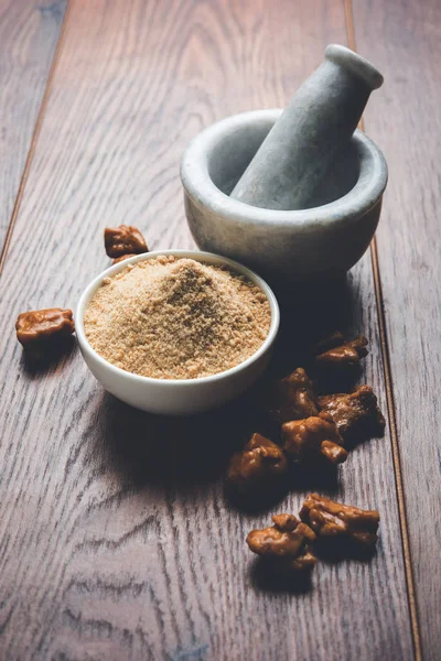 Asafoetida tårta och pulver eller Hing eller Heeng som är en viktig ingrediens i indisk matrecept med stor träslev och murbruk, selektivt fokus — Stockfoto