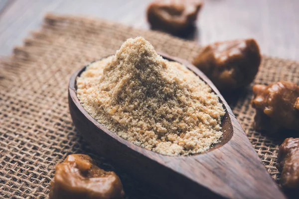 Asafoetida cake and powder or Hing or Heeng which is an important ingredient in Indian food recipes with big wooden spoon and mortar, selective focus — Stock Photo, Image