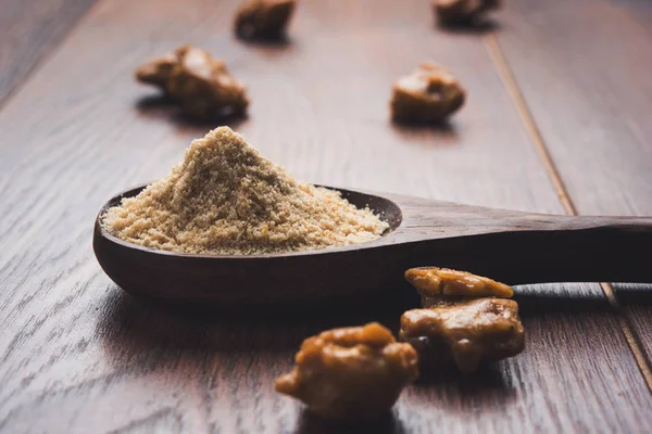 Şeytantersi kek ve toz veya Hing veya Hint yemek tarifleri ile büyük tahta kaşık ve harç, seçici odak önemli bir madde olan Heeng