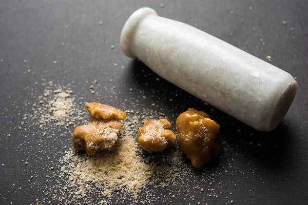 Şeytantersi kek ve toz veya Hing veya Hint yemek tarifleri ile büyük tahta kaşık ve harç, seçici odak önemli bir madde olan Heeng