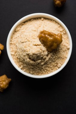 Şeytantersi kek ve toz veya Hing veya Hint yemek tarifleri ile büyük tahta kaşık ve harç, seçici odak önemli bir madde olan Heeng