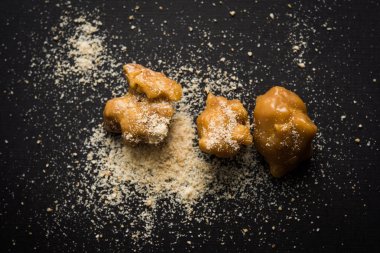 Şeytantersi kek ve toz veya Hing veya Hint yemek tarifleri ile büyük tahta kaşık ve harç, seçici odak önemli bir madde olan Heeng