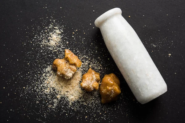 Şeytantersi kek ve toz veya Hing veya Hint yemek tarifleri ile büyük tahta kaşık ve harç, seçici odak önemli bir madde olan Heeng