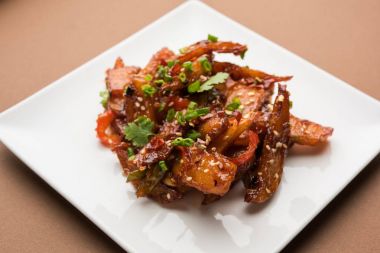 Tatlım kırmızı biber patates veya patates dilimleri, popüler Hint-Çin başlangıç tarifi, susam ve soğan ile süslenmiş. seçici odak