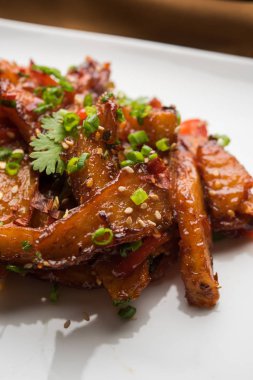 Tatlım kırmızı biber patates veya patates dilimleri, popüler Hint-Çin başlangıç tarifi, susam ve soğan ile süslenmiş. seçici odak